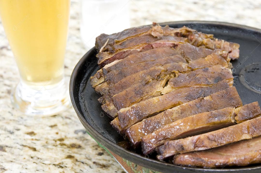 Carnes comida sobre balcão com copo de suco