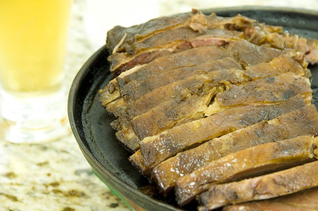Carnes comida sobre balcão com copo de suco