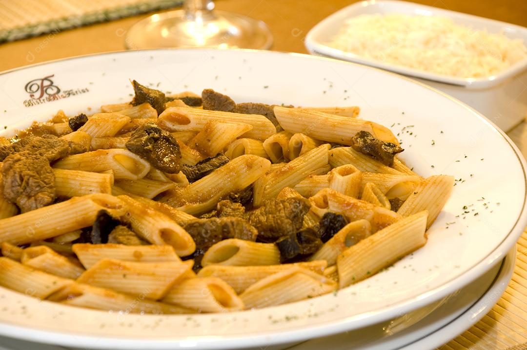 Prato de comida sobre uma mesa de madeira macarrão