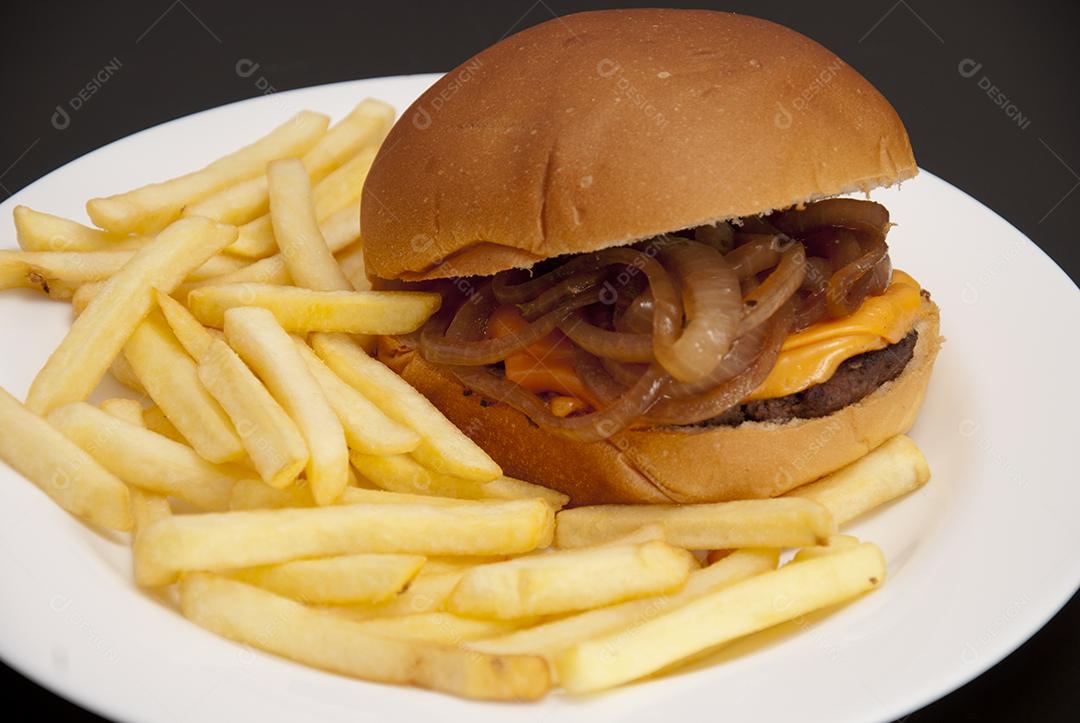 Hambúrguer com queijo derretido, maionese, alface batata frita prato branco