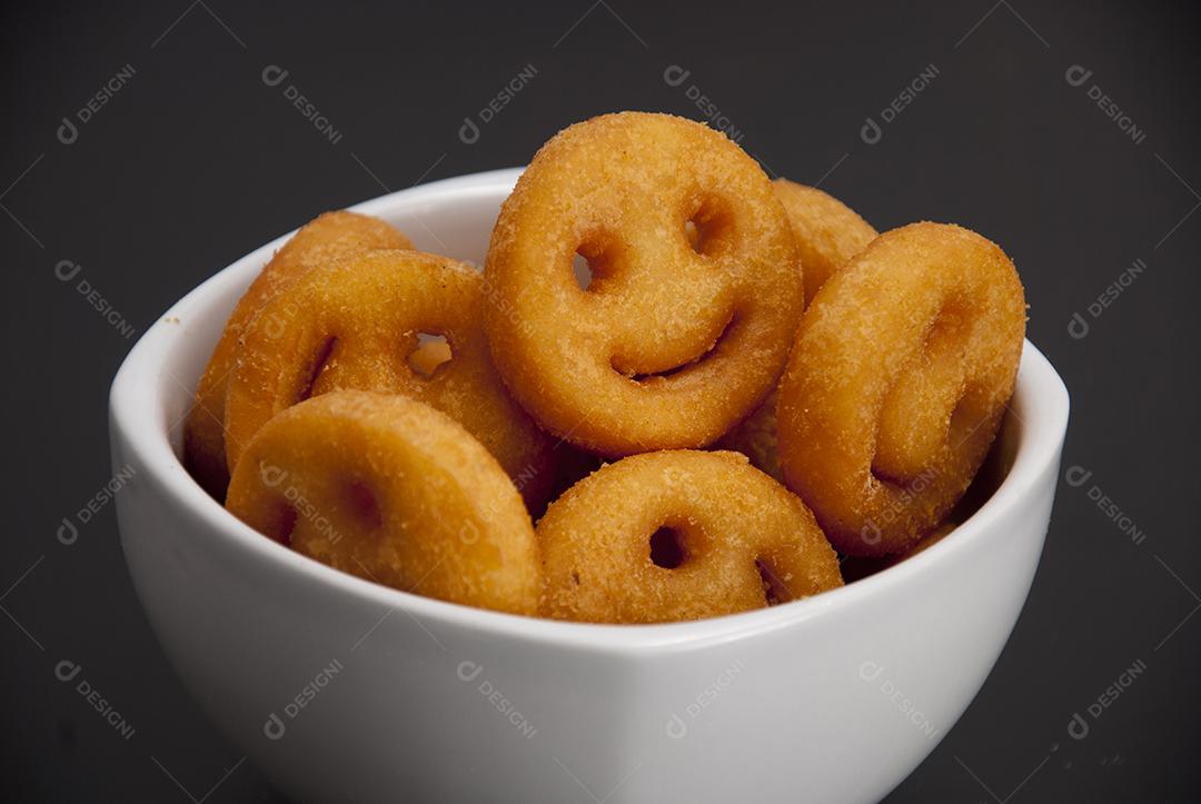 Salgados em formas de carinhas sobre tigela pocelona