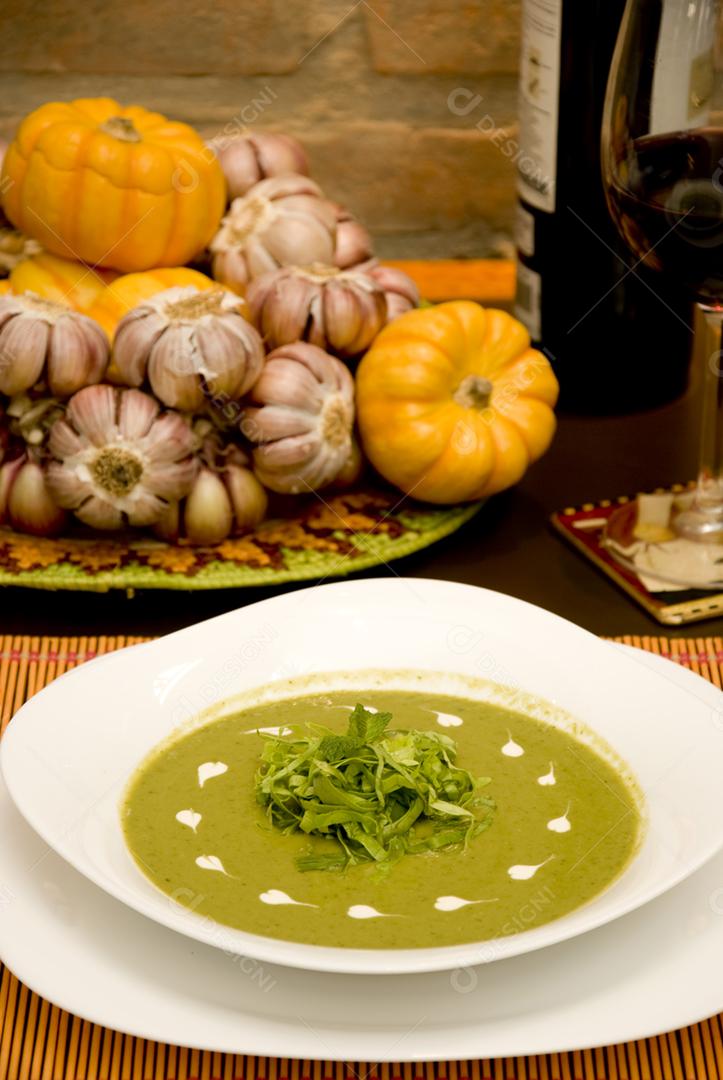 Sopa de ervilha verde servida em prato branco
