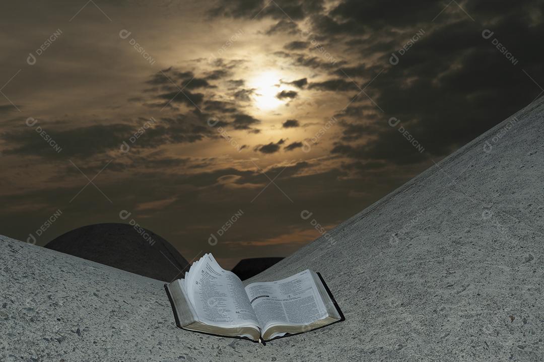Abra a Bíblia em um bloco de quebra-mar com um nascer do sol deslumbrante