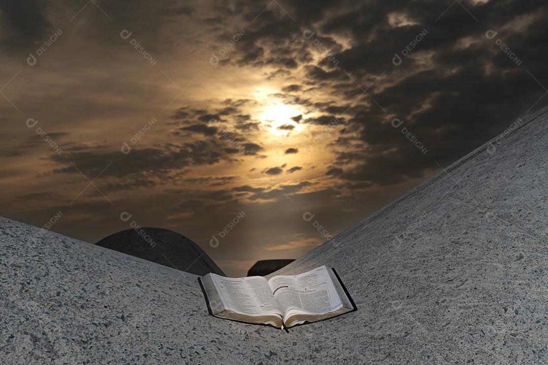 Abra a Bíblia em um bloco de quebra-mar com um nascer do sol deslumbrante