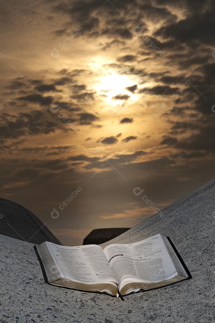 Abra a Bíblia em um bloco de quebra-mar com um nascer do sol deslumbrante