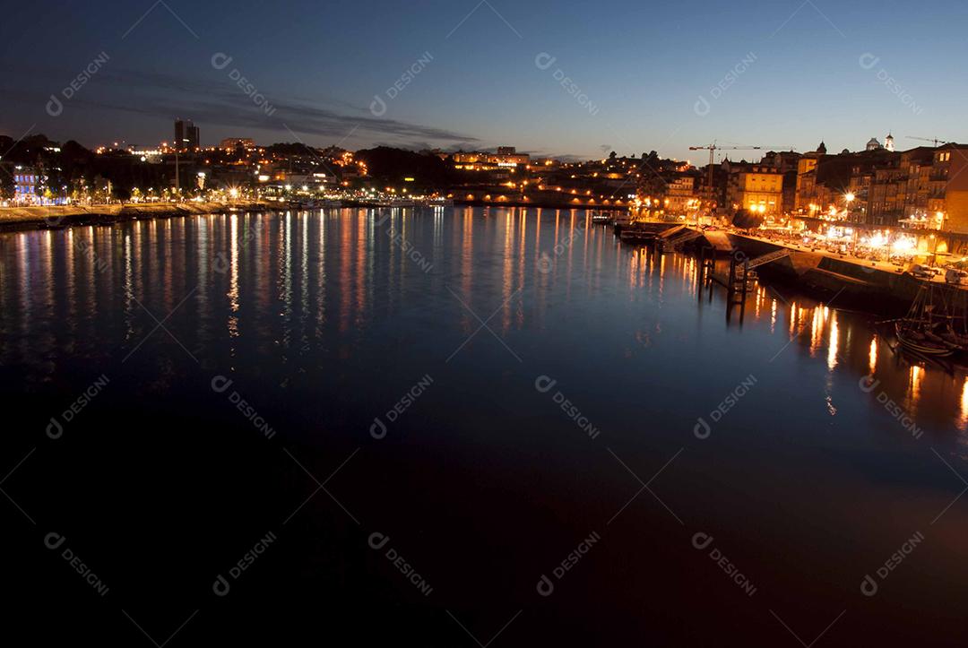 Paisagem noturna de luzes acessas e um lago