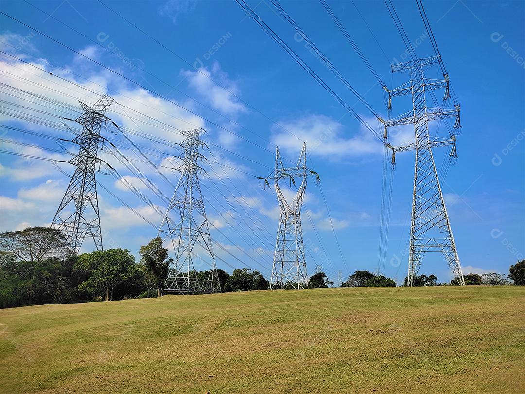 Torres de transmissão de energia sobre campo floresta