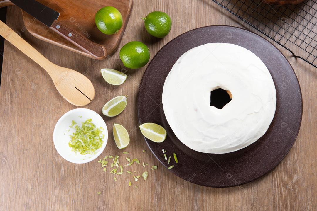 Bolo de frutas de limão úmido no prato com rodelas de limão na mesa de madeira