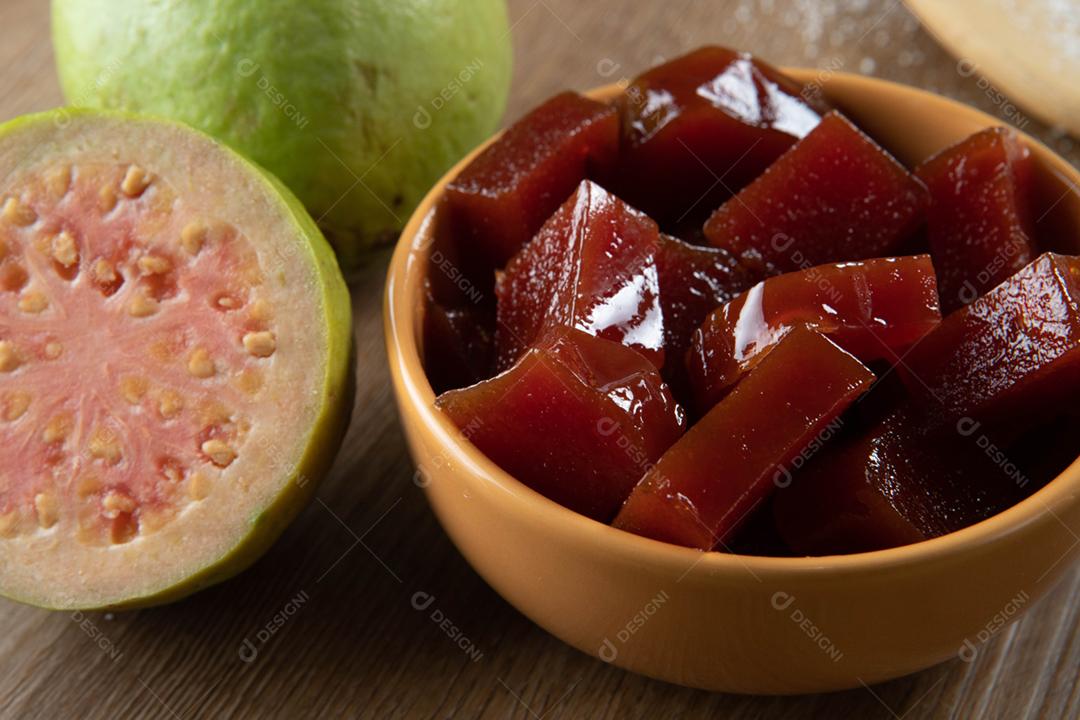 Lata amarela com doce de goiaba cortada em cubos com goiabada no verso