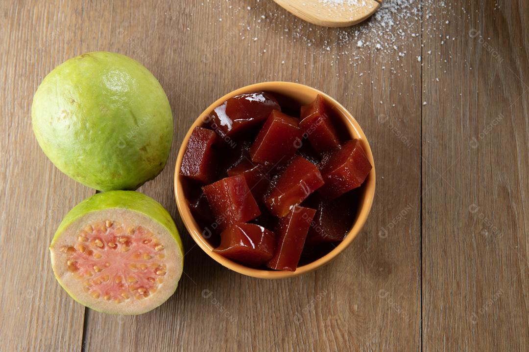 Lata amarela com doce de goiaba cortada em cubos com goiabada no verso