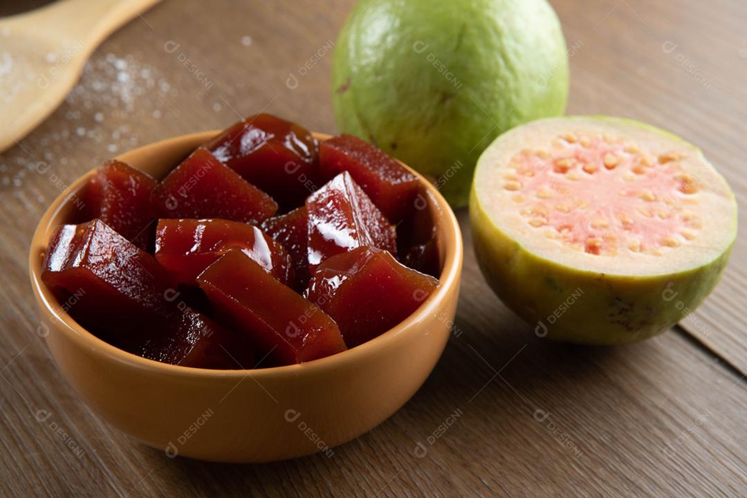 Lata amarela com doce de goiaba cortada em cubos com goiabada no verso
