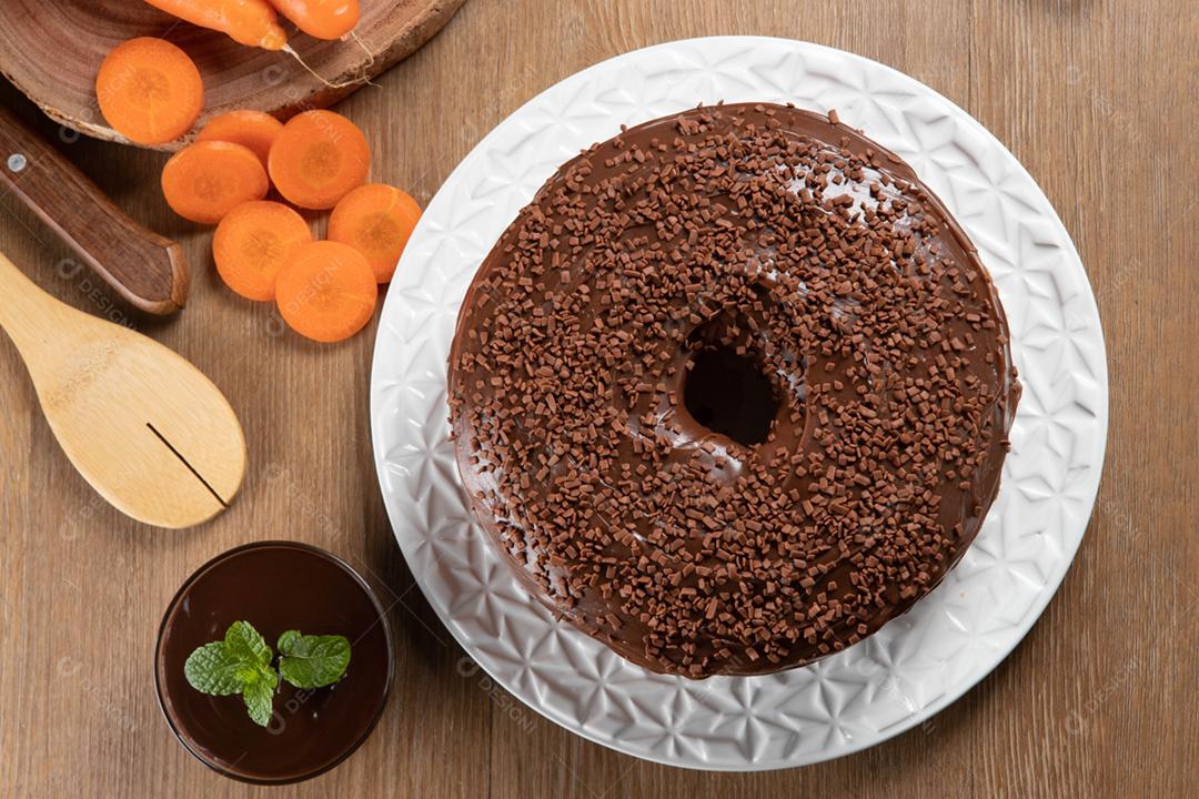 Bolo de cenoura brasileiro com cobertura de chocolate na mesa de madeira wi