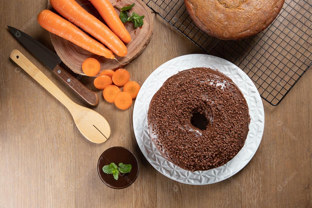 Bolo de cenoura brasileiro com cobertura de chocolate na mesa de madeira wi