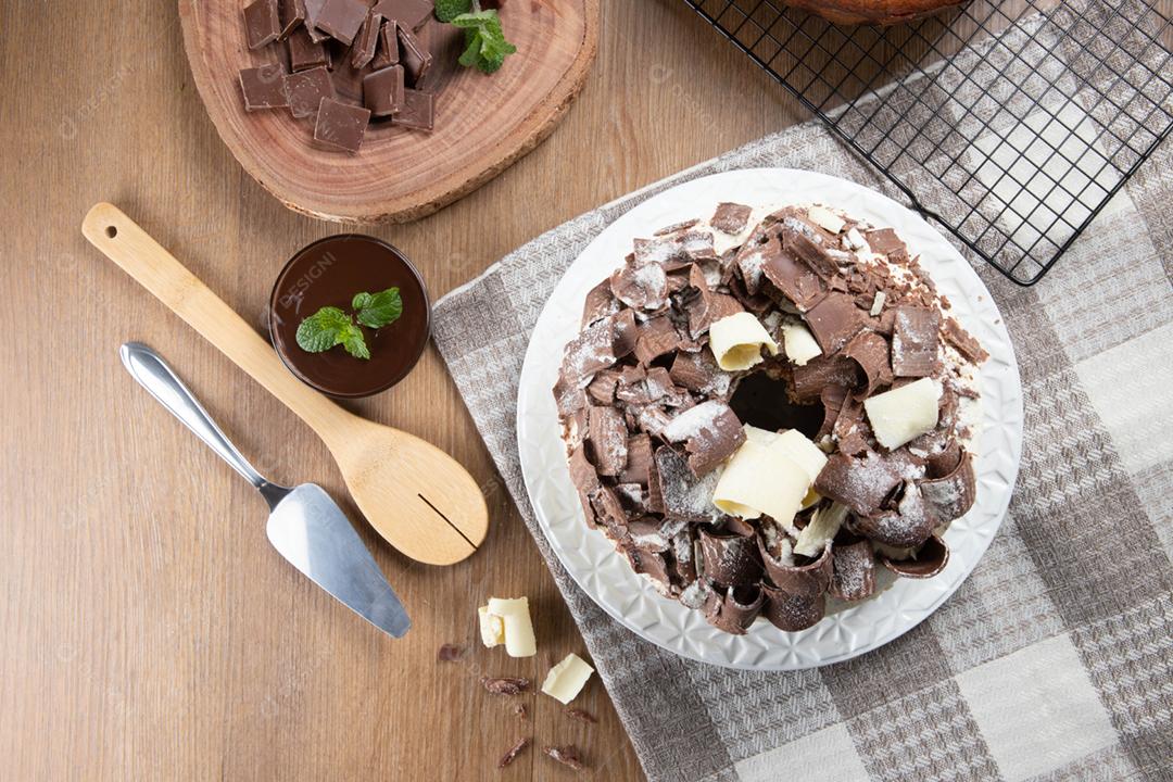 Chocolate branco e bolo de chocolate escuro dois amores na mesa de madeira