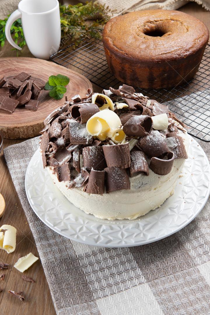 Chocolate branco e bolo de chocolate escuro dois amores na mesa de madeira