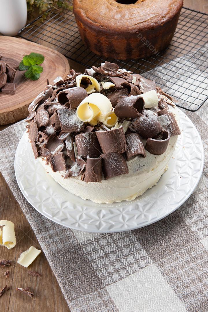 Chocolate branco e bolo de chocolate escuro dois amores na mesa de madeira