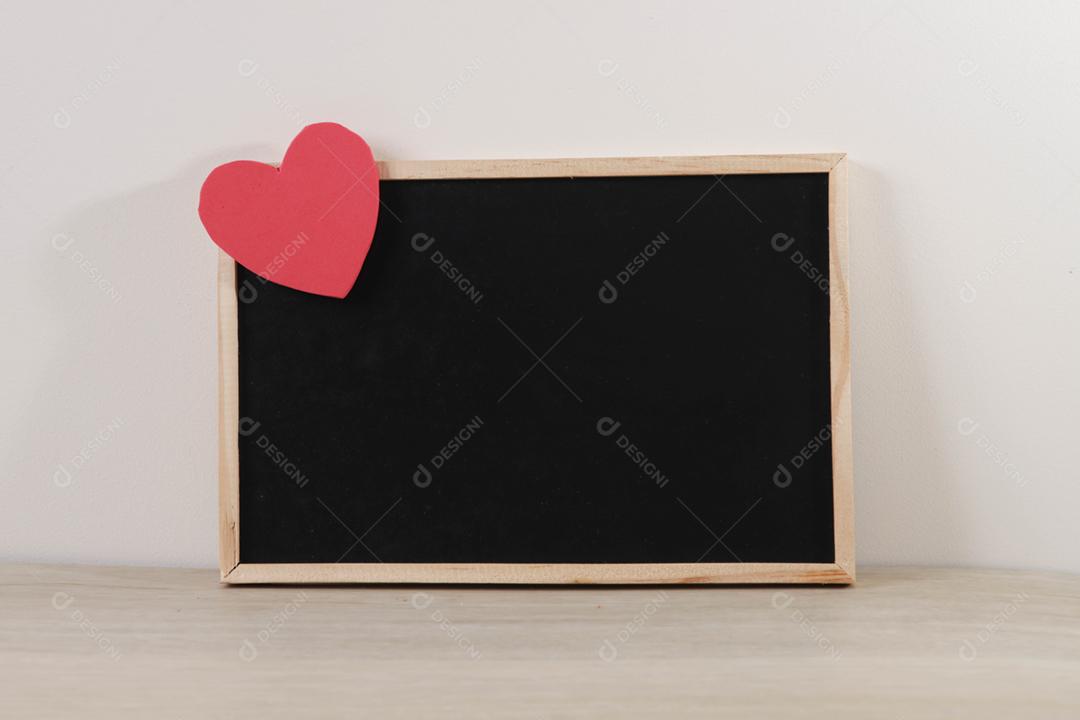 Quadro-negro e corações em fundo de madeira