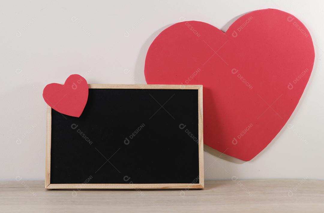 Quadro-negro e corações em fundo de madeira