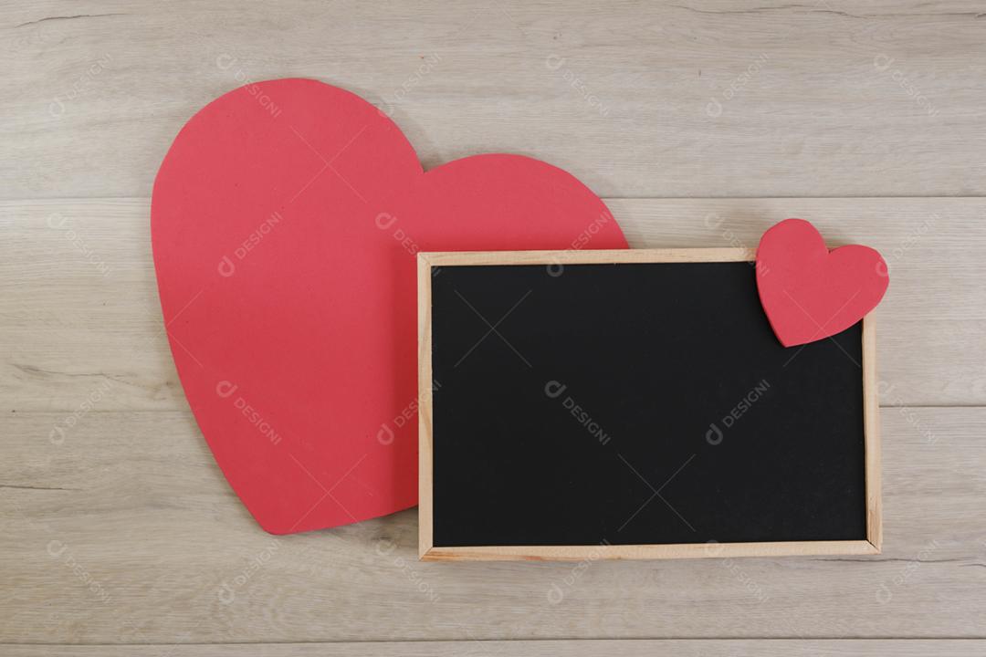 Blackboard and hearts on wooden background