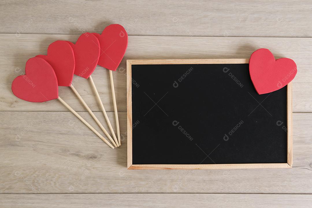 Quadro-negro e corações em fundo de madeira