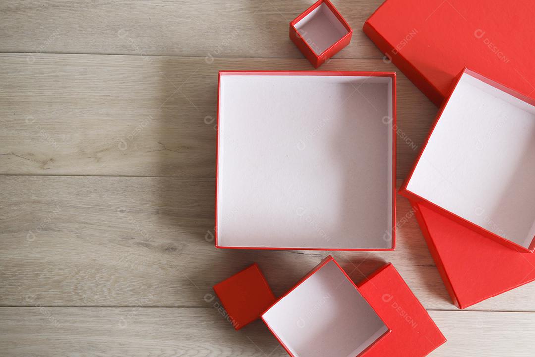 Caixas de presente vermelhas sobre fundo de madeira com espaço.