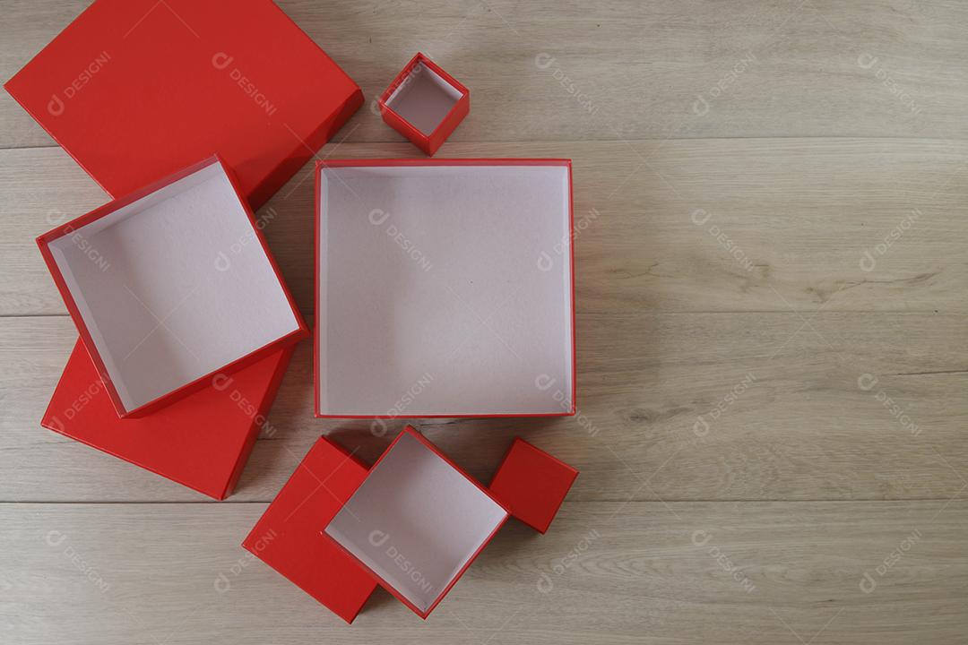 Caixas de presente vermelhas sobre fundo de madeira com espaço.