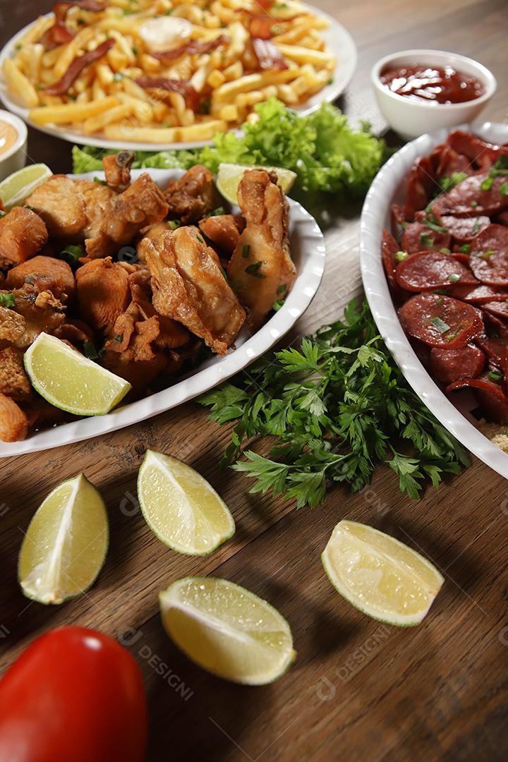 Porção de linguiça calabresa com limão, batata frita, bacon e frango frito. Alface, cebolinha, ketchup e maionese.