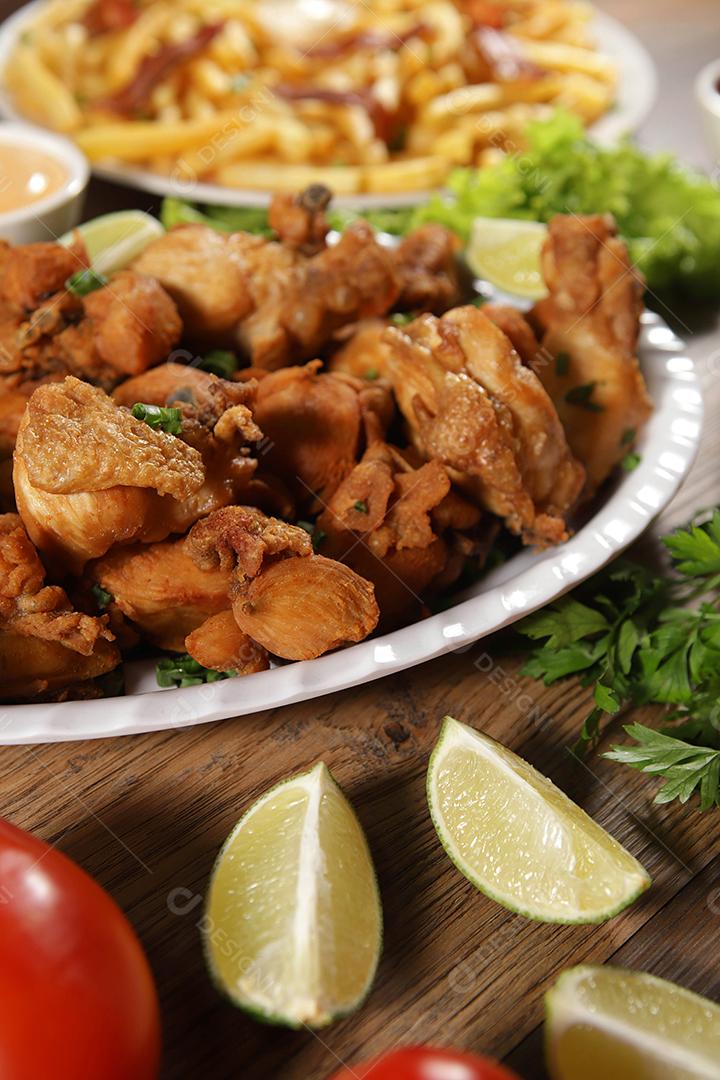 Porção de frango frito com limão. Alface, cebolinha, ketchup e maionese.