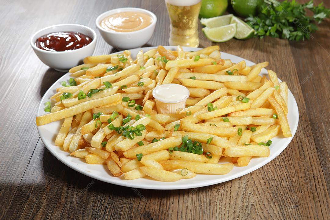 Porção de batatas fritas. Alface, batata, cebolinha, tomate, ketchup e maionese.
