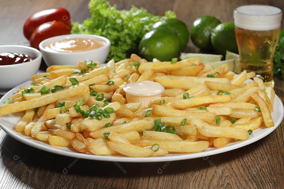 Porção de batatas fritas. Alface, batata, cebolinha, tomate, ketchup e maionese.