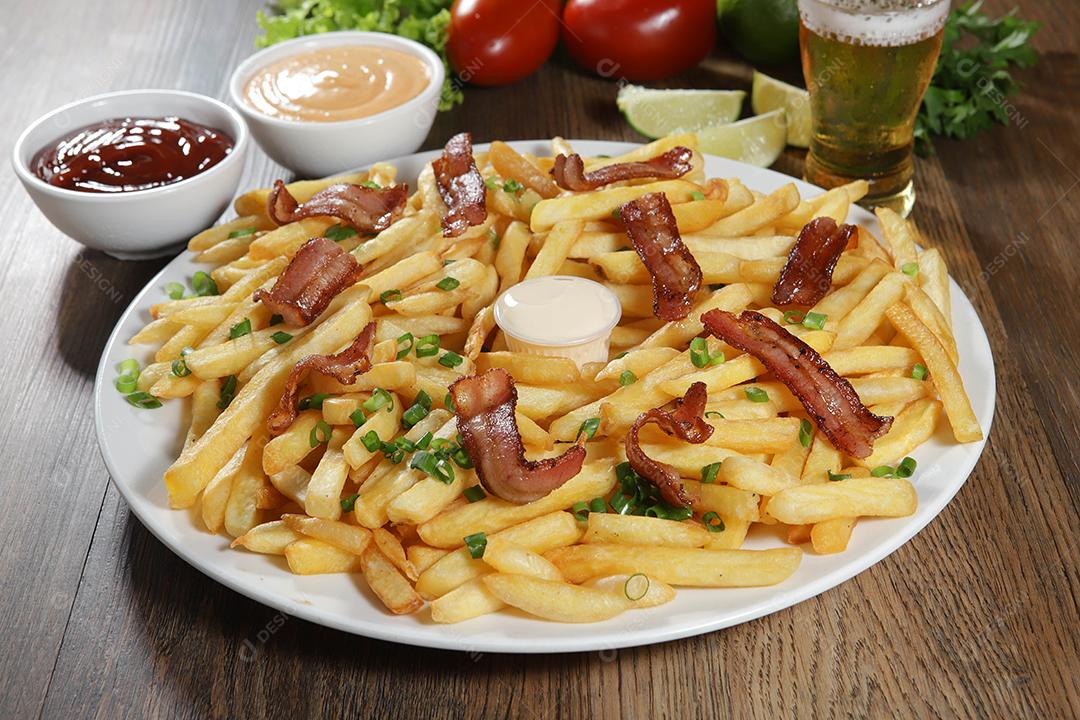 Porção de batata frita com bacon. Alface, batata, cebolinha, tomate, ketchup e maionese.