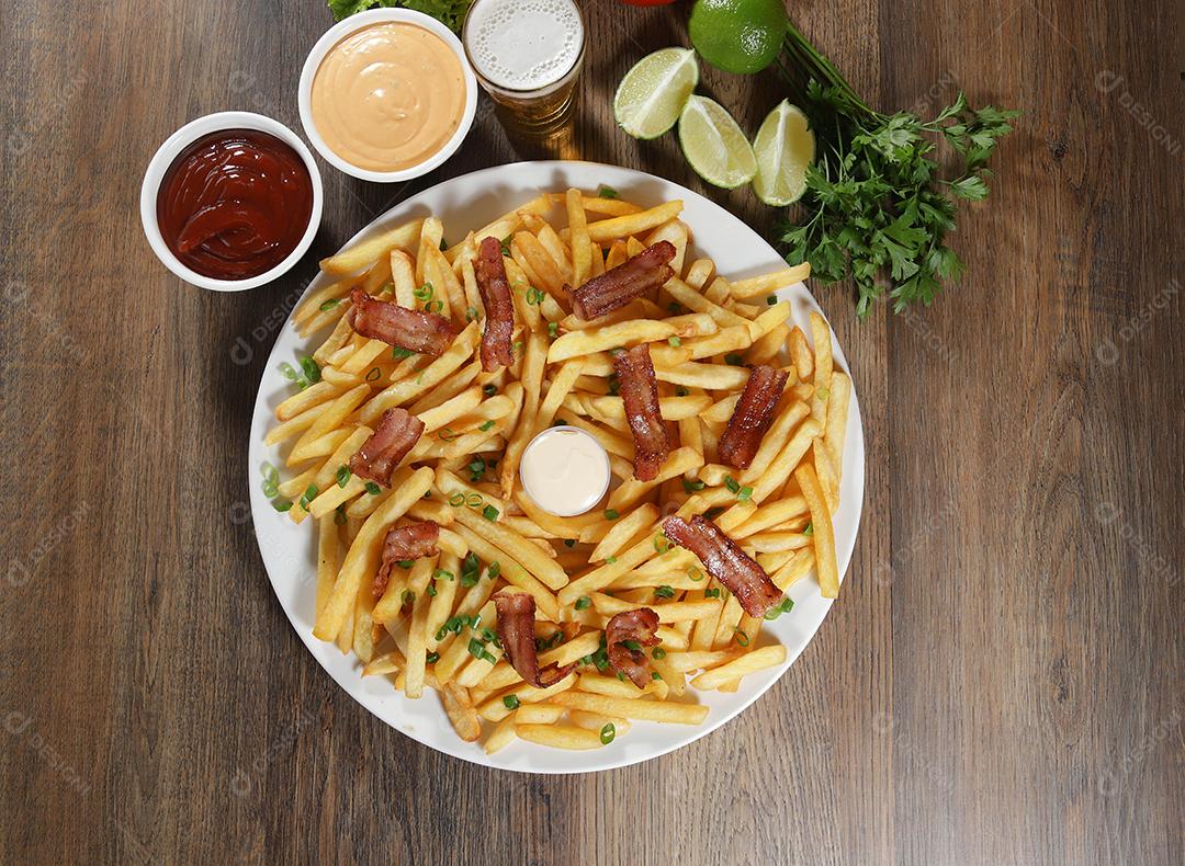 Porção de batata frita com bacon. Alface, batata, cebolinha, tomate, ketchup e maionese.