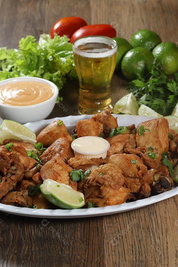 Porção de frango frito com limão. Alface, cebolinha, ketchup e maionese.