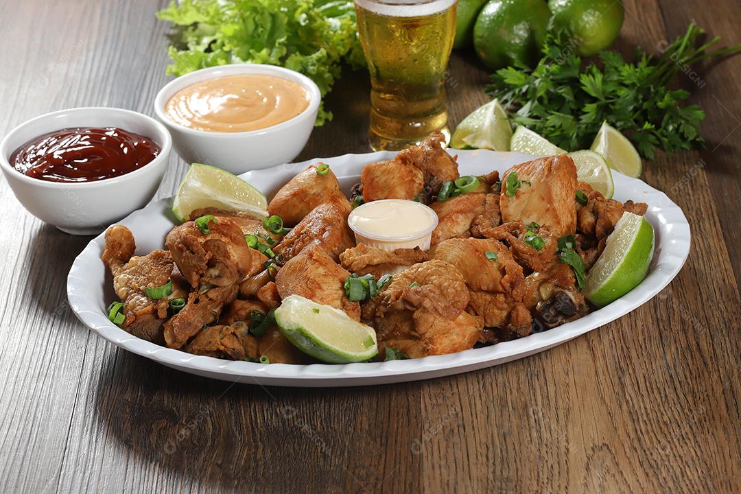 Porção de frango frito com limão. Alface, cebolinha, ketchup e maionese.