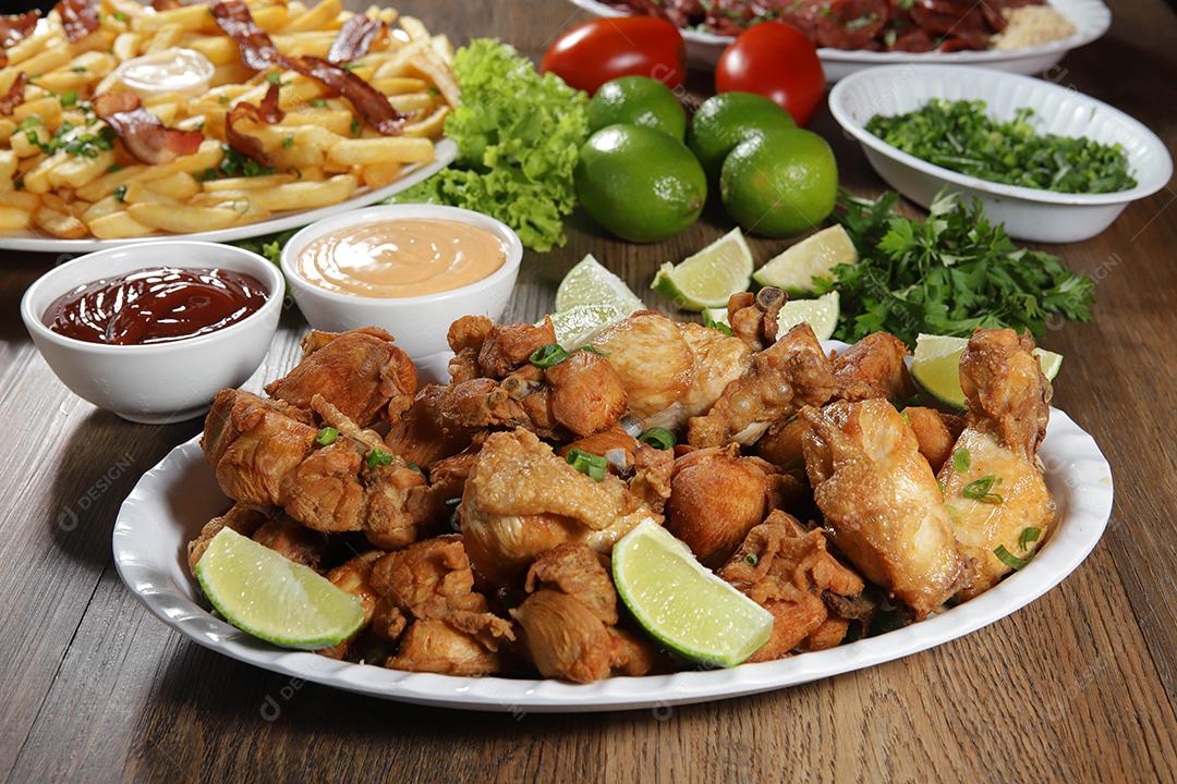 Porção de frango frito com limão. Alface, cebolinha, ketchup e maionese.