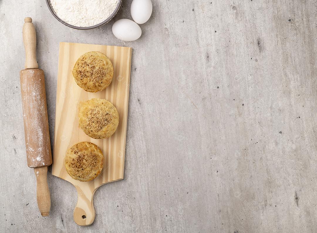 Tortas caseiras sobre placa de madeira com ingredientes