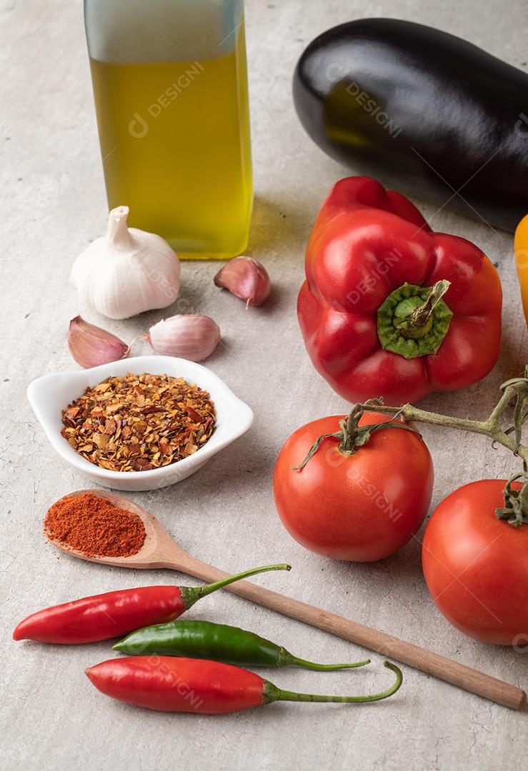 Tomate, pimentão, azeite, berinjela e alho sobre a mesa de madeira. Comida mediterrânea.