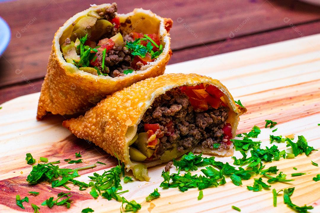 Pastel de vento partido ao meio recheado com carne