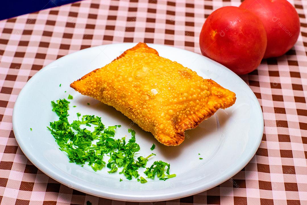 Pastel de vento partido ao meio recheado com carne