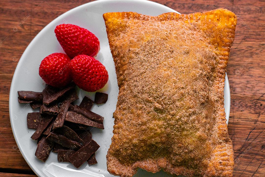 Delicioso pastel de vento doce servido com chocolate e morango