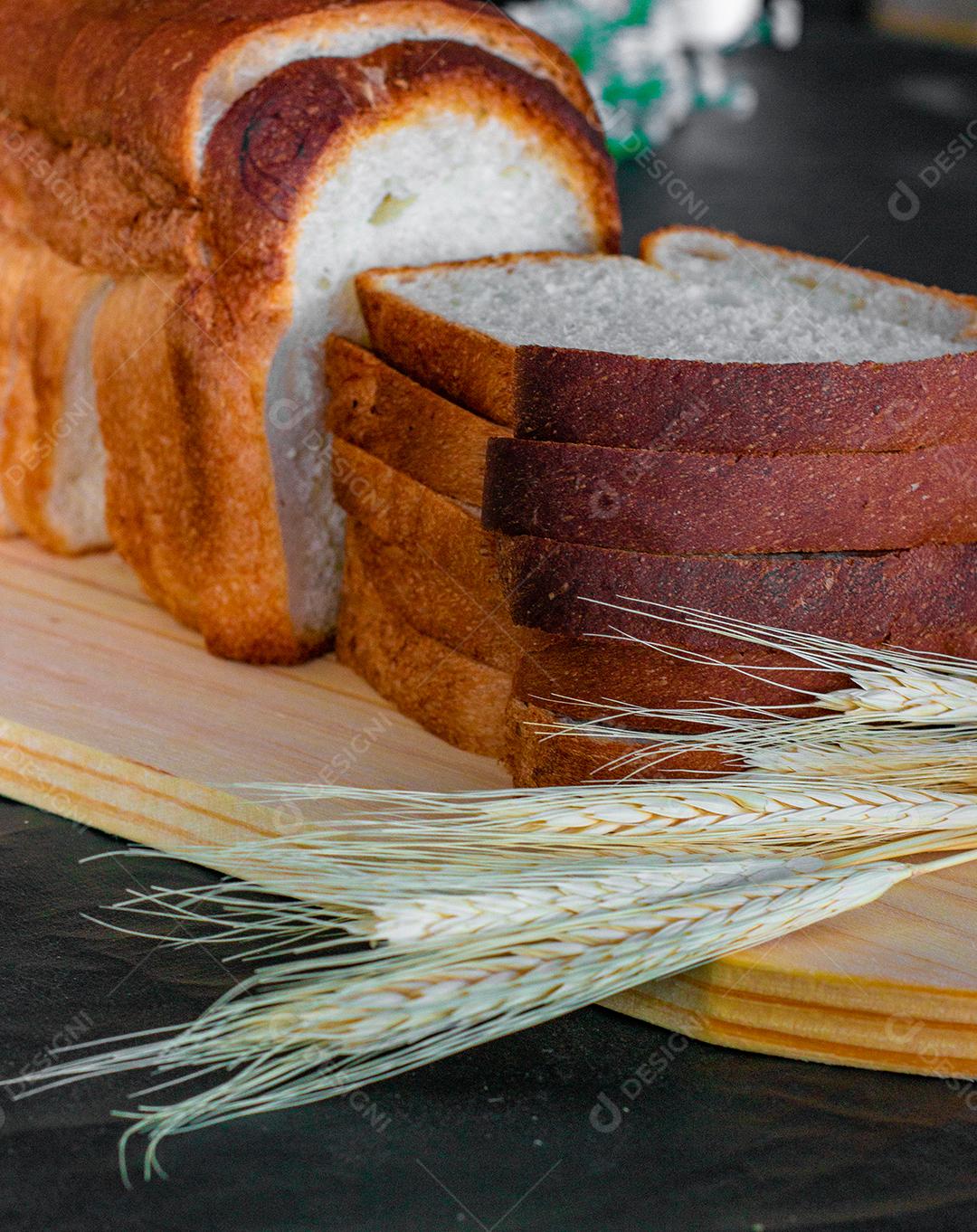 Delicioso pão de forma e trigo sobre tábua de madeira