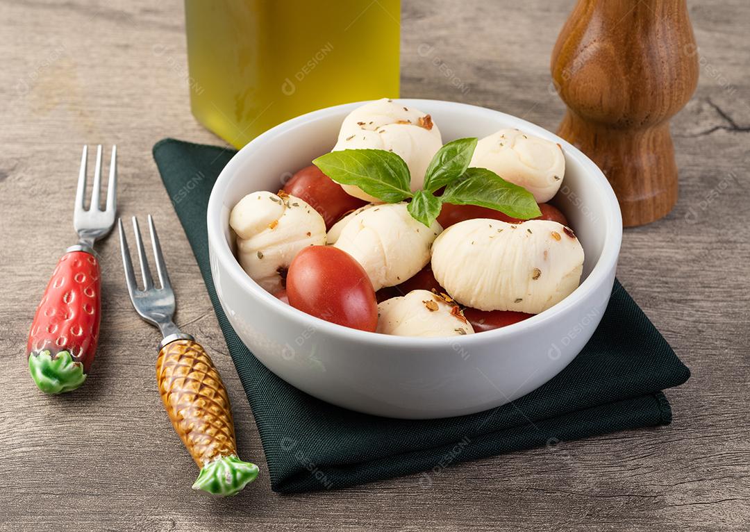 Mussarela Nozinho ou Nó, queijo branco fresco artesanal típico brasileiro com temperos, manjericão e tomate cereja.