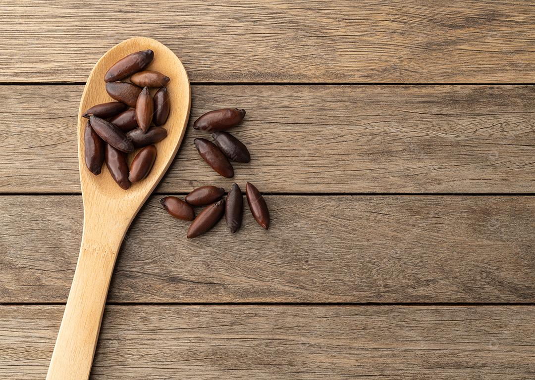 Nozes de baru brasileiras em uma colher sobre a mesa de madeira