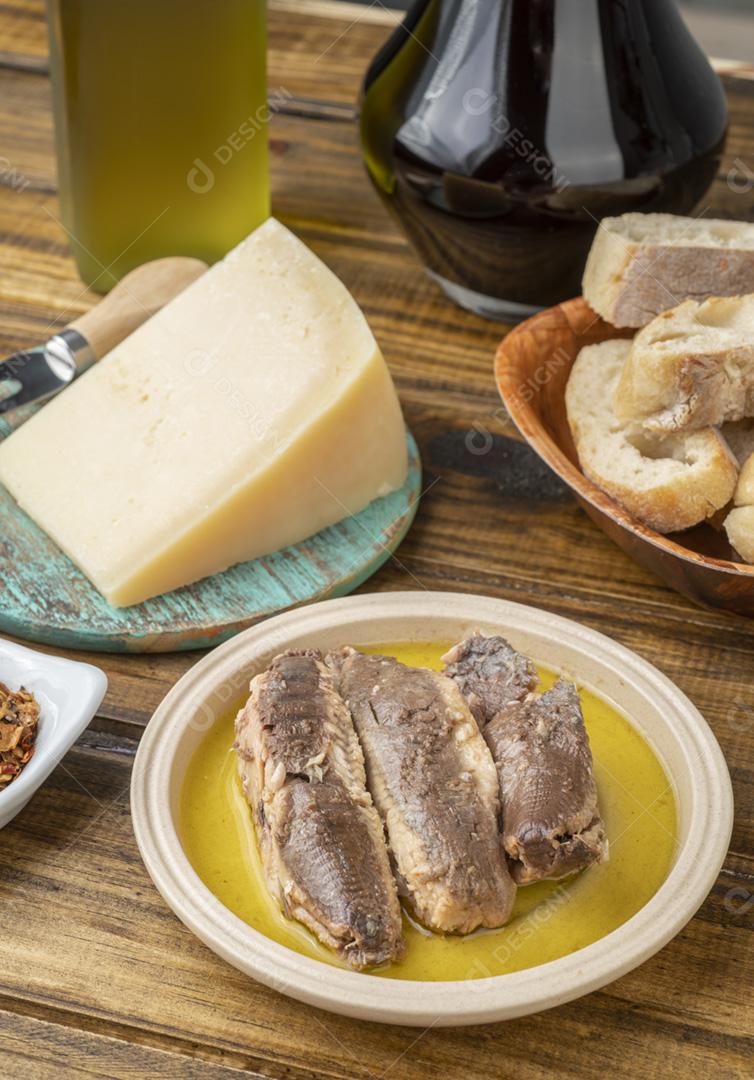 Peixe, azeite, queijo parmesão, pão e vinho sobre aba de madeira