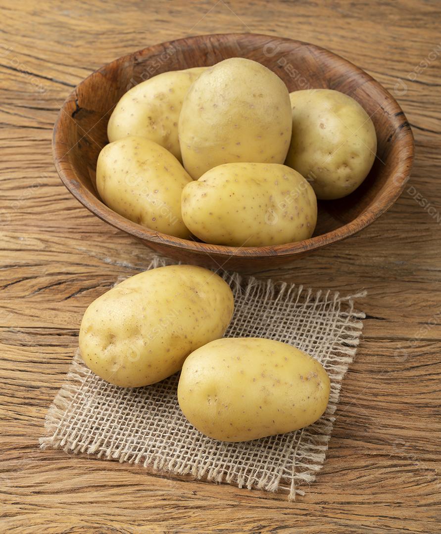 Batatas em uma tigela sobre a mesa de madeira.