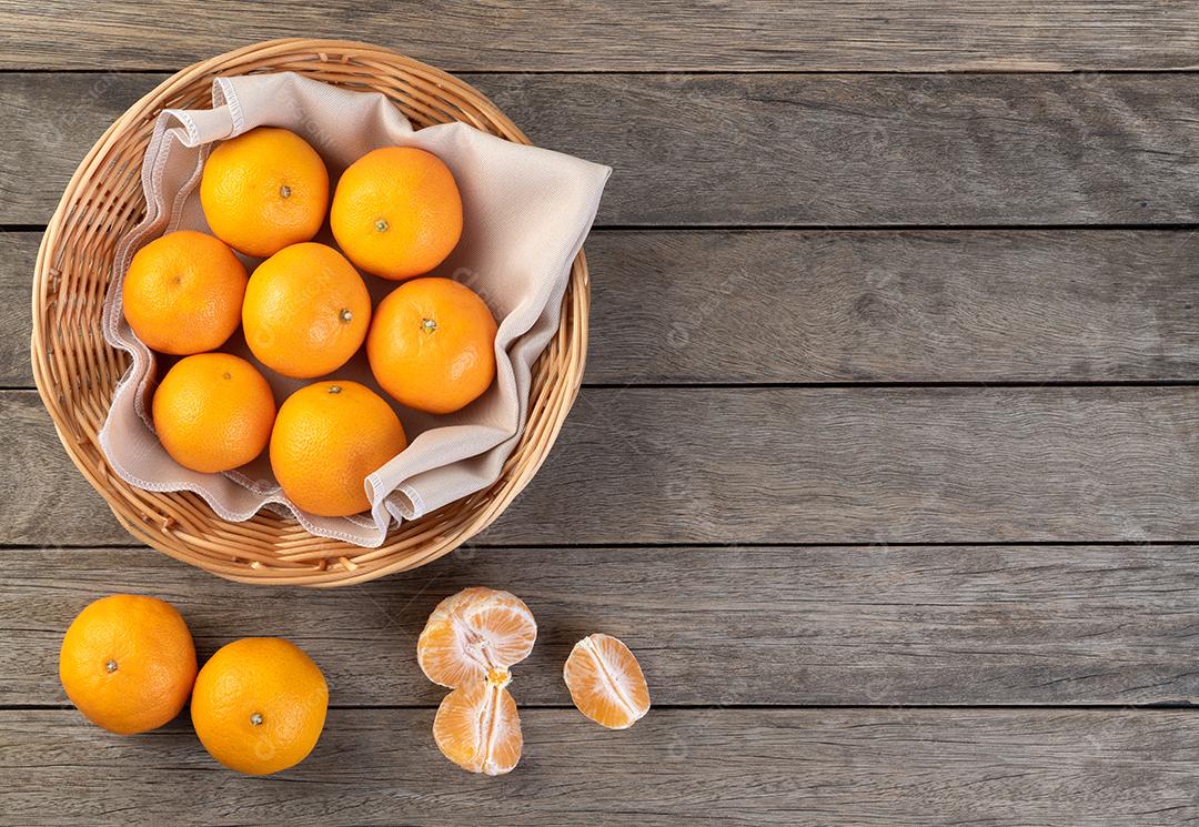 Mini tangerinas em uma cesta sobre mesa de madeira