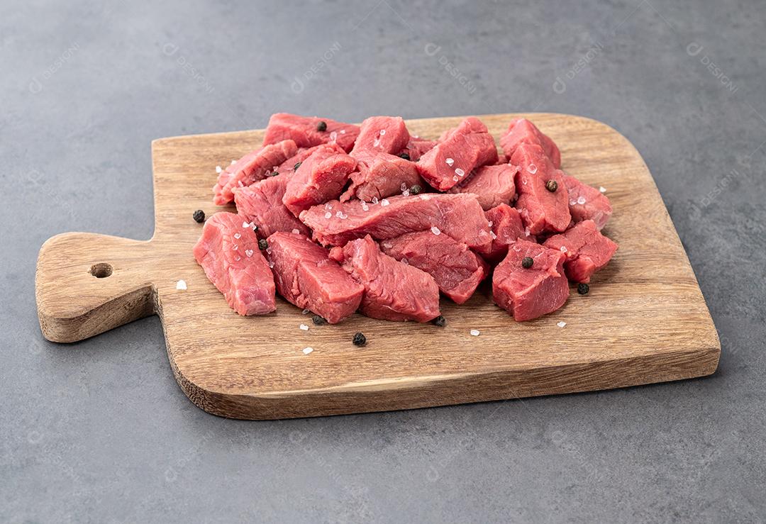 Chopped top meat on wooden board with spices.