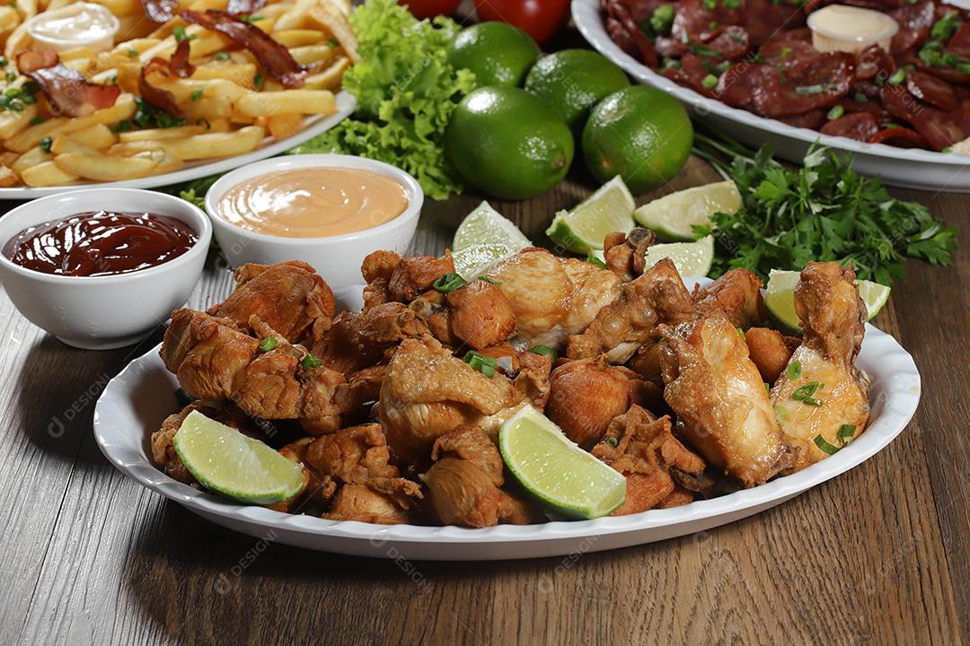 Porção de frango frito com limão. Alface, cebolinha, ketchup e maionese.