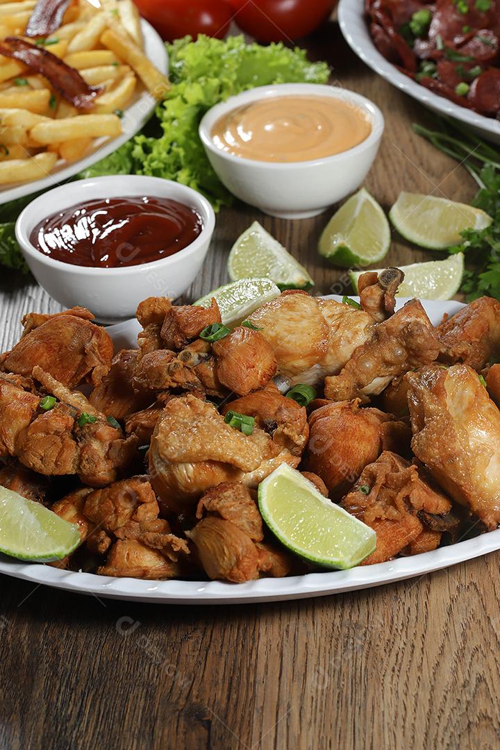 Porção de frango frito com limão. Alface, cebolinha, ketchup e maionese.