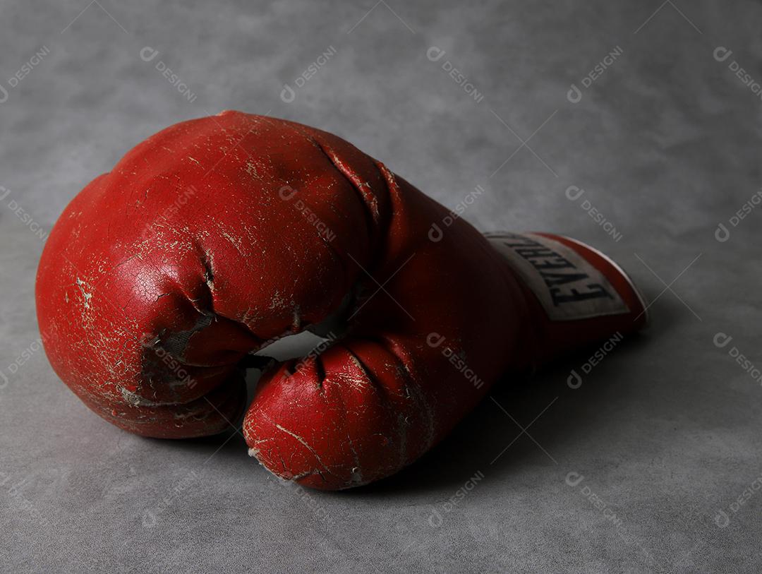 Luvas de boxe velhas Eternas no chão do ginásio após o treino. Fundo cinza concreto grunge.